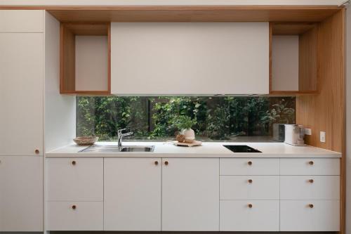 a white kitchen with a sink and a window at Reflections Evans Head - Holiday Park in Evans Head