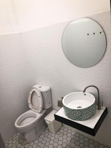 a bathroom with a sink and a toilet and a mirror at Ban Rub Lom Pool Villa 3 difference villas in Rayong