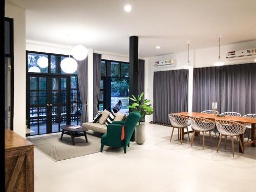 a living room with a couch and a table at Ban Rub Lom Pool Villa 3 difference villas in Rayong