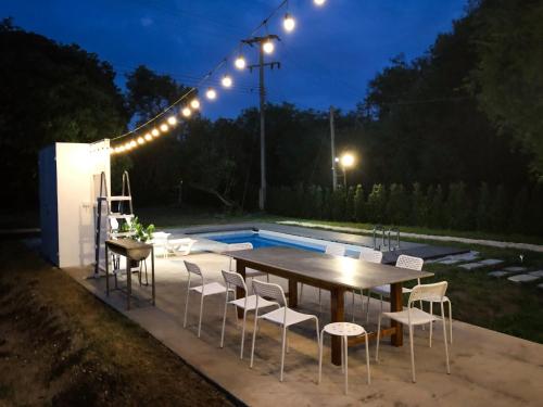 a table and chairs next to a pool at night at Ban Rub Lom Pool Villa 3 difference villas in Rayong