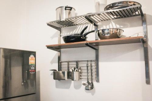 a kitchen with a shelf and a refrigerator at Ban Rub Lom Pool Villa 3 difference villas in Rayong