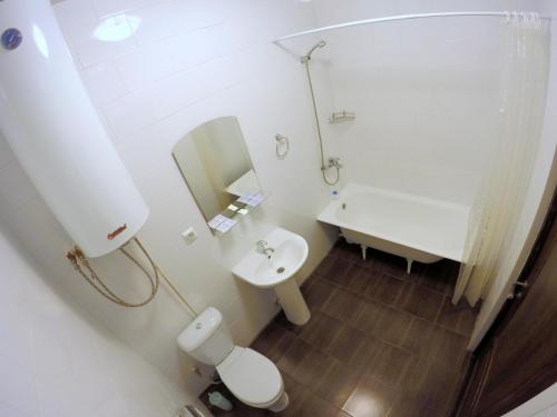 ペルミにあるHotel Aziaの白いバスルーム(トイレ、シンク付)