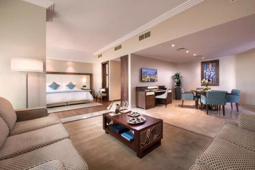 a living room with a couch and a room with a bed at Stella Di Mare Dubai Marina Hotel in Dubai