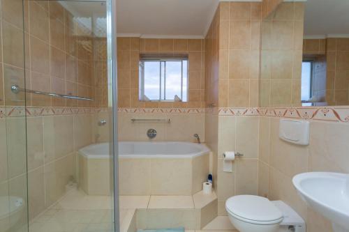a bathroom with a tub and a toilet and a sink at Breathtaking views in Blouberg! in Bloubergstrand