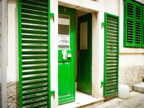 a green door in a building with green shutters at Accommodation Old Town Vitaic in Korčula