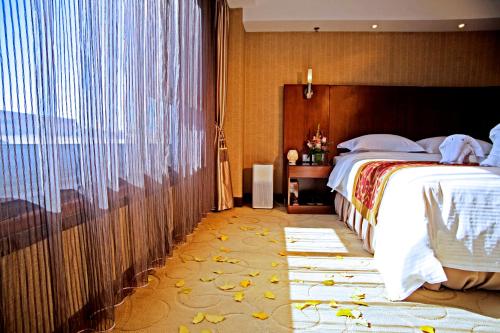 a bedroom with a large bed and a large window at Xijiao Hotel Beijing in Beijing