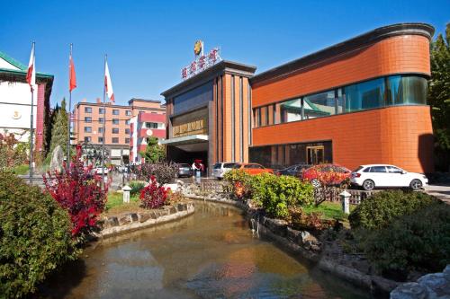 a building with a pond in front of a building at Xijiao Hotel Beijing in Beijing