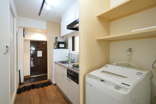 a small kitchen with a washer and a refrigerator at Roppongi Japan House602 in Tokyo