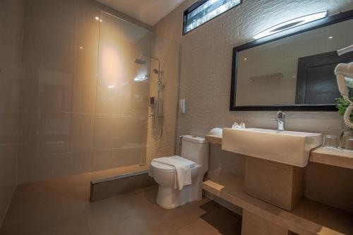 y baño con lavabo, aseo y espejo. en Bintan Spa Villa Beach Resort & Spa, en Telukbakau