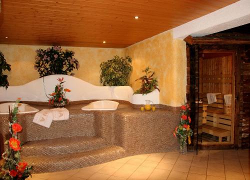 ein Badezimmer mit Whirlpool-Badewanne mit Pflanzen in der Unterkunft Pension Andreas in Sölden