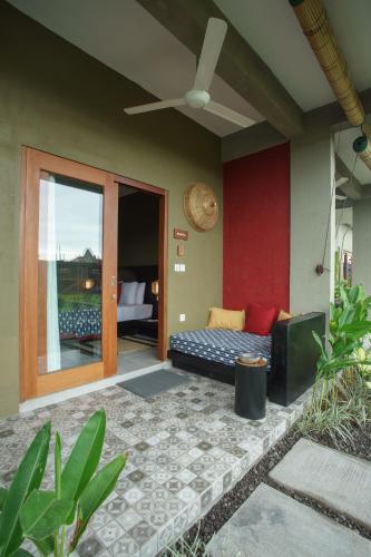 a living room with a couch and a ceiling fan at Wasabi in Canggu