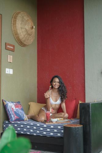 a woman in a bikini sitting on a bed at Wasabi in Canggu
