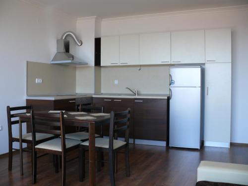 a kitchen with a table and a refrigerator at Complex Kentavar - Free Fast WiFi in Sveti Vlas