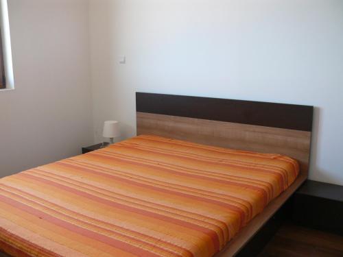 a bedroom with a bed with an orange blanket on it at Complex Kentavar - Free Fast WiFi in Sveti Vlas