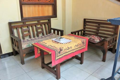 two chairs and a table with a table cloth on it at Arjuna Homestay Ubud in Ubud