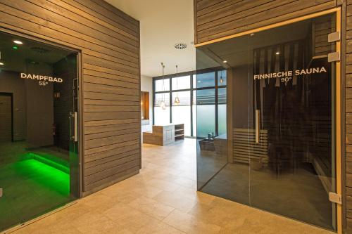 ベルガーエンデ・レートヴィッシュにあるSunny Suite 14 - charmant und elegant mit Pool und Saunabereichの緑の光が差し込むガラス戸
