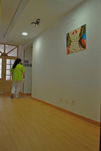 a woman walking through a room with a painting on the wall at Hotel Centro Vitoria AutoCheckIn in Vitoria-Gasteiz