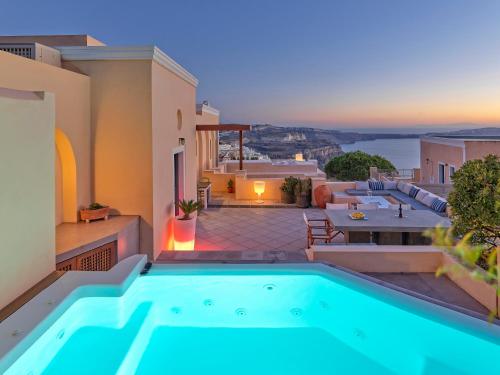 a villa with a swimming pool and a patio at Archipel Mansion in Fira