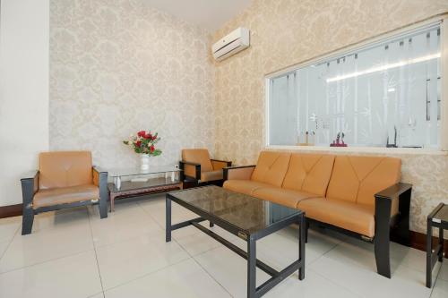 a living room with a couch and two chairs and a table at RedDoorz Plus at Karebosi Area 2 Makassar in Makassar
