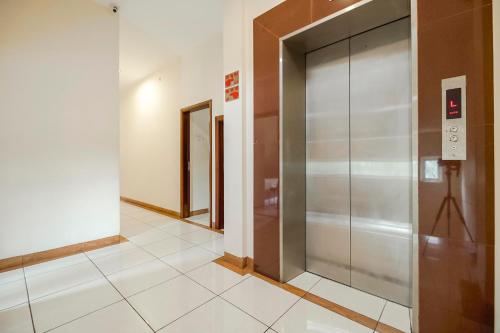 a hallway with a elevator in a building at RedDoorz Plus at Karebosi Area 2 Makassar in Makassar