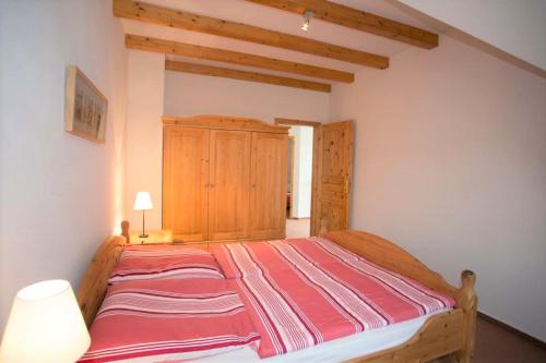 - une chambre avec un grand lit en bois dans l'établissement Landhaus am Goor, à Putbus