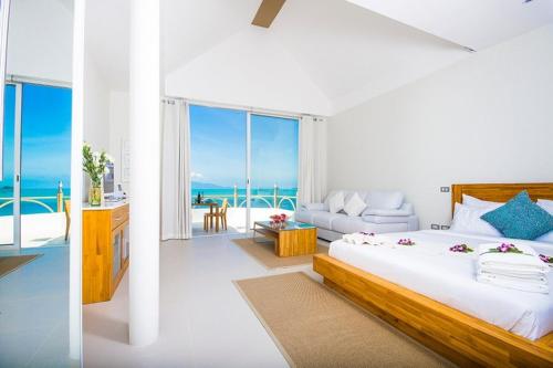 a bedroom with a bed and a view of the ocean at B1 Beachfront Apartments in Bophut 