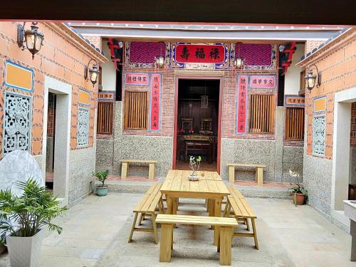 a wooden table in front of a building at Kinmen Huquian 58 in Jinhu