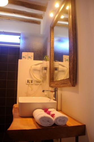 a bathroom with a sink and a mirror and towels at Maisha Marefu Apartments in Kiwengwa