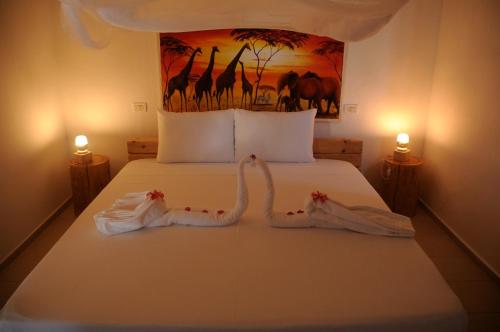 a bedroom with a bed with two towels on it at Maisha Marefu Apartments in Kiwengwa