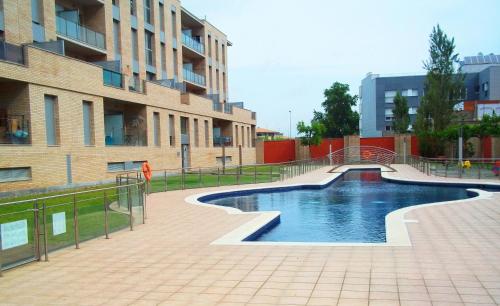 une piscine en face d'un bâtiment dans l'établissement Apart-rent Apartment Puig Rom 0149, à Empuriabrava