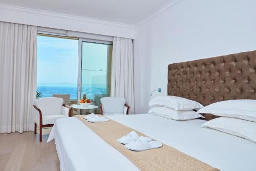 a hotel room with two beds and a window at Grecian Park in Protaras