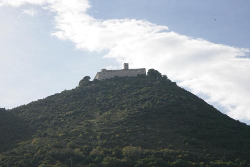 a building on top of a hill with clouds at Hotel Piazza Marconi in Cassino