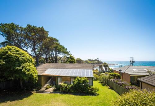 a house with solar panels on the side of it at 74 Ocean Parade in Dalmeny