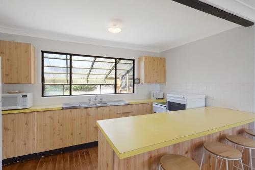 a kitchen with a yellow counter and a window at 74 Ocean Parade in Dalmeny