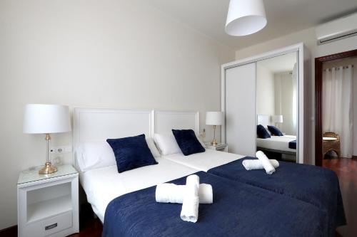 1 dormitorio con 2 camas individuales con sábanas azules y blancas en Classbedroom Fira Business Apartment en Barcelona