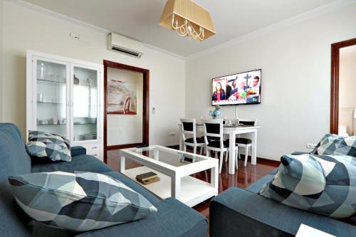 a living room with a blue couch and a table at Classbedroom Fira Business Apartment in Barcelona