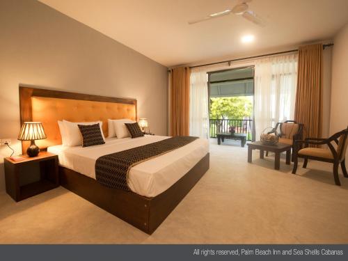 an apartment bedroom with a bed and a balcony at Palm Beach Inn & Sea Shells Cabanas in Bentota