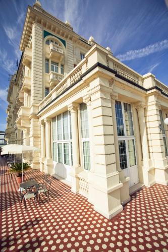 a building with a bench in front of it at Grand Hotel Cesenatico in Cesenatico