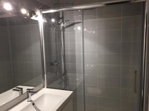 ラ・ロシェルにあるVue Plage des Minimes PONANT 3 Appt 406のバスルーム(洗面台付きのシャワー、ガラス張りのシャワードア付)