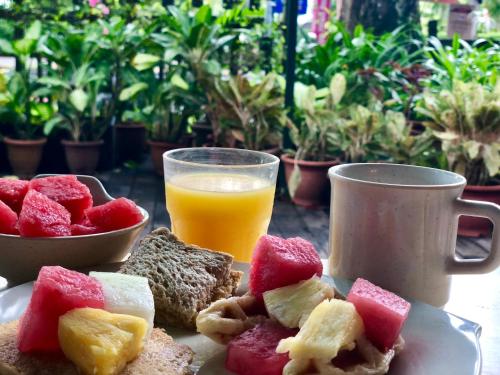 新加坡Siloso Beach Resort - Sentosa的一盘水果和一杯橙汁