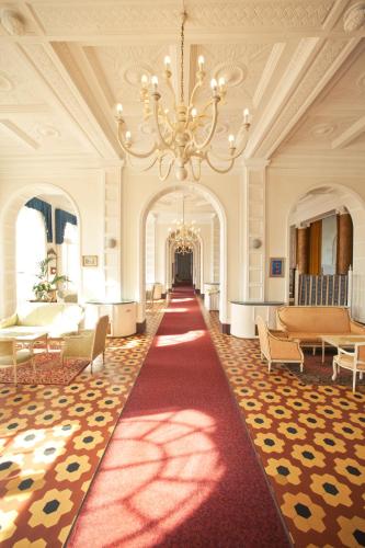 a large room with a red carpet and a chandelier at Grand Hotel Cesenatico in Cesenatico