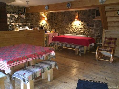 a room with two beds and a table and chairs at Cabana "Trei Brazi " Retezat in Rîu de Mori