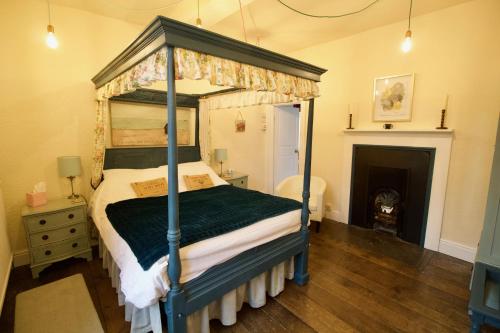 a bedroom with a canopy bed and a fireplace at Calcutts House in Ironbridge