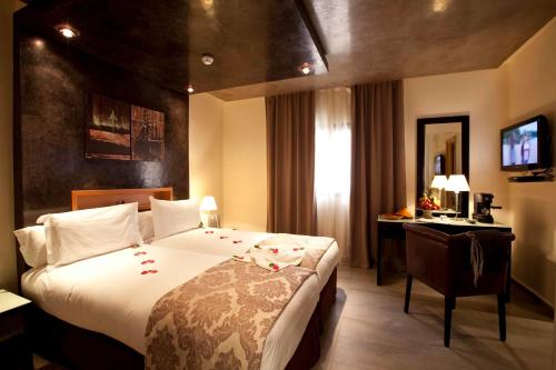 a hotel room with a large bed and a desk at Dellarosa Boutique Hotel and Spa in Marrakech