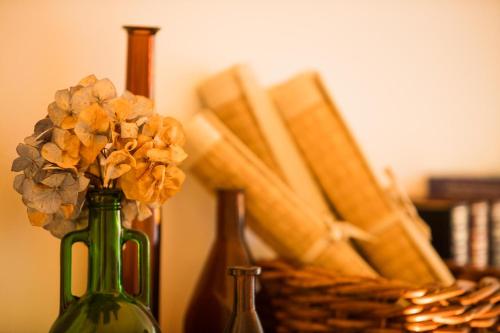 a green vase with flowers in it next to a basket at Landhaus Hindenburg in Bad Gleichenberg