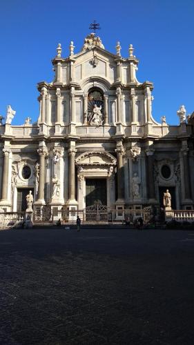 a large white building with a clock on it at Domoikos in Catania