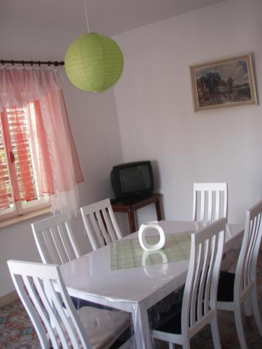 a dining room with a white table and chairs at Barko apartment and rooms in Hvar