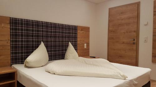a bedroom with a bed with white sheets and pillows at Apart Luneta in Ladis
