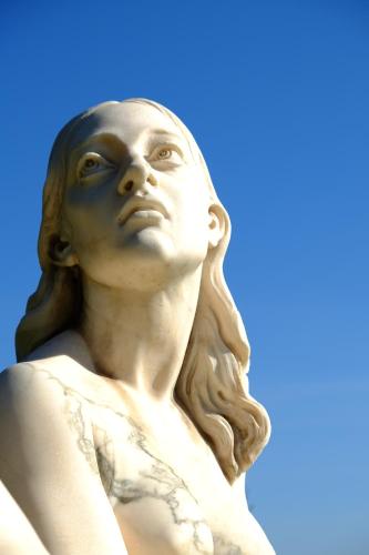 a statue of a woman against a blue sky at Domoikos in Catania