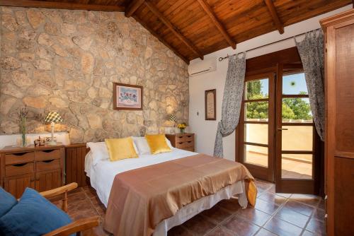 a bedroom with a bed and a stone wall at Hacienda Los Olivos in Ronda